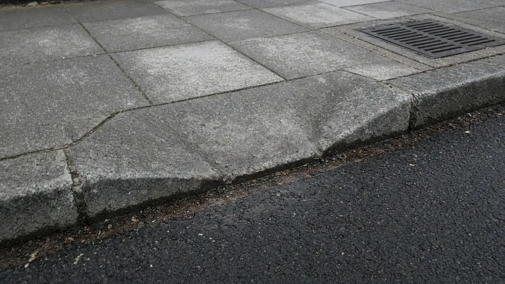 Close-up of lowered kerb stones and a transition kerb at a driveway crossing